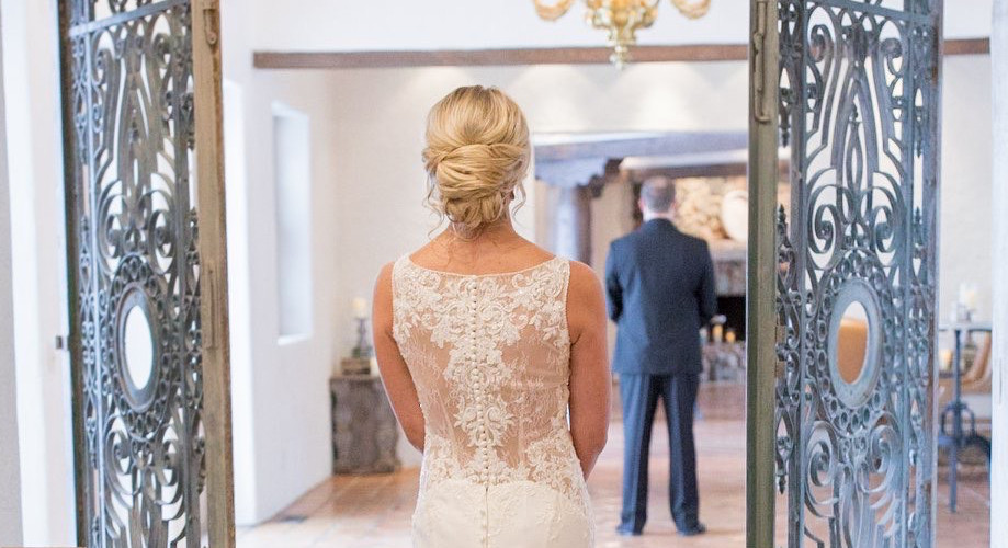 Bride standing in doorway with groom in background